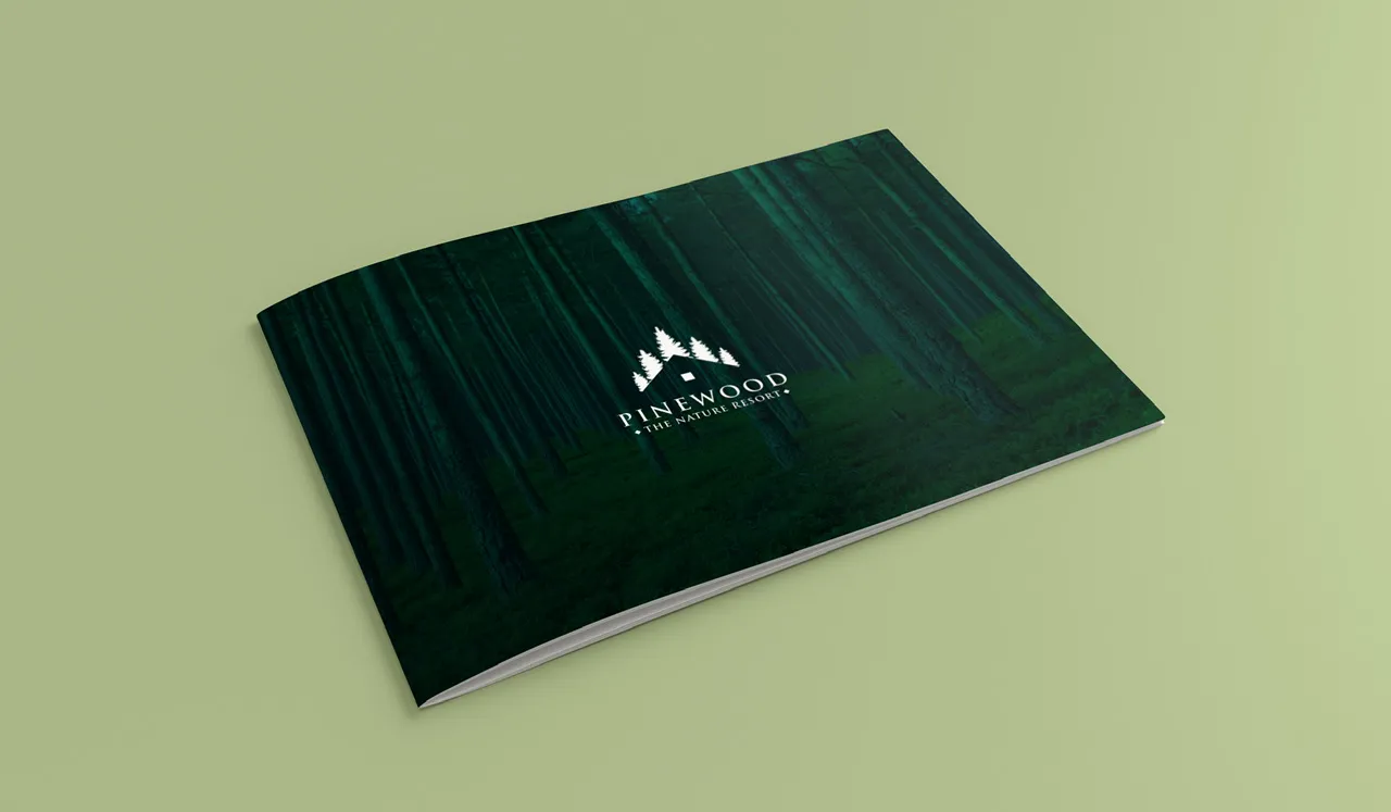 A5 brochure cover mockup on sage green: a dark pine-forest photograph with the white Pinewood “The Nature Resort” logo.