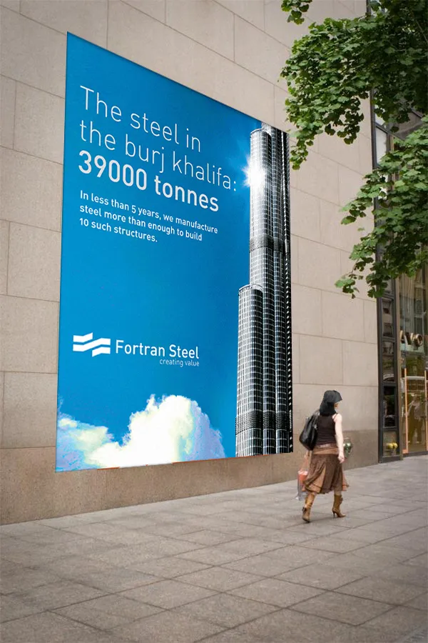 Street-level wall poster of the sky-blue Fortran Steel Burj Khalifa ad.